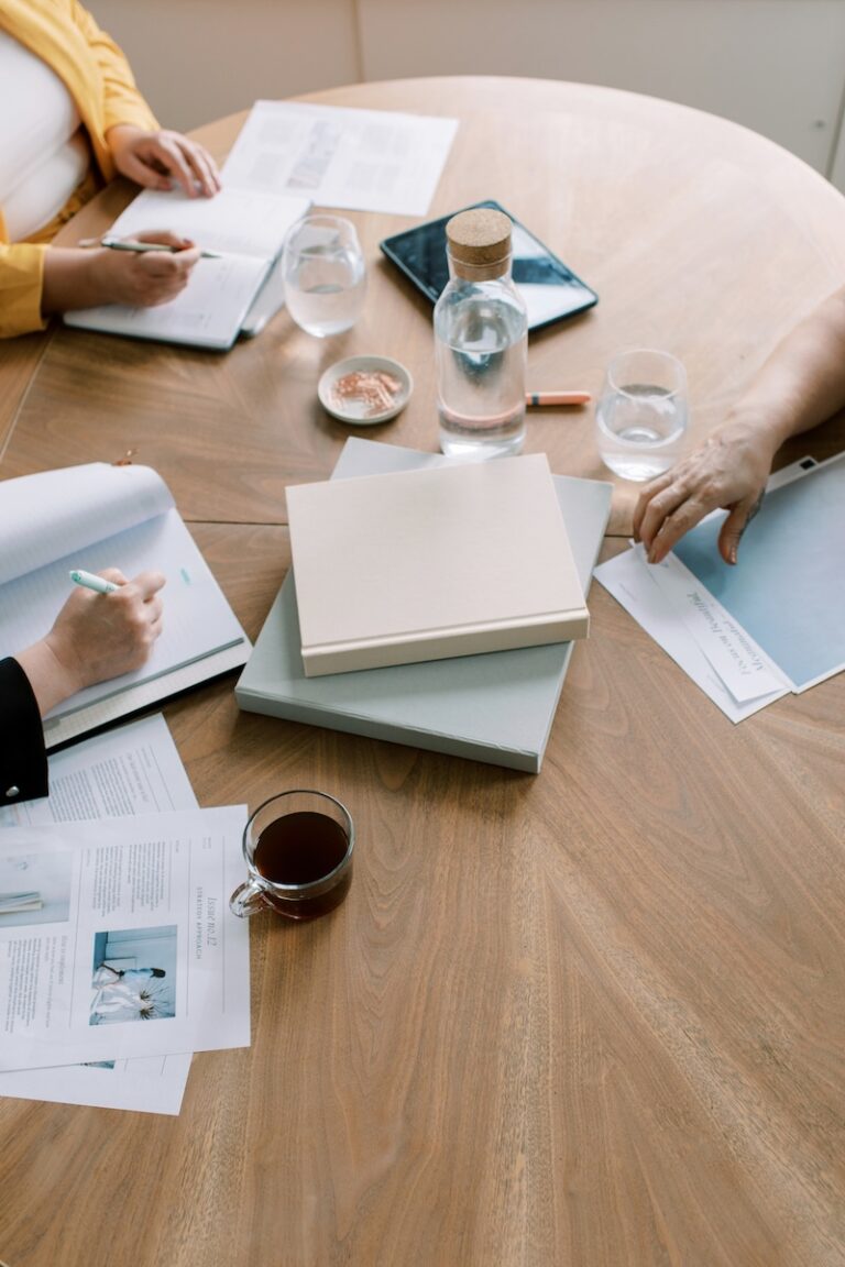 Three people at a table reviewing gift and property documents during a nonprofit gift acceptance review
